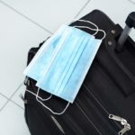 Medical mask and travel suitcase. Travel ban during the coronavirus epidemic.